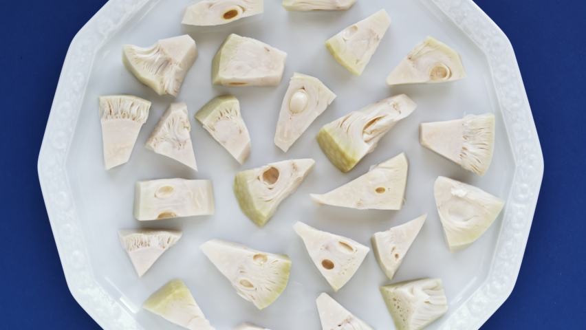 Canned jackfruit pieces on a plate. Great vegan fruit substitution for meat. Table spin, zoom-in.