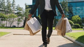 Taking video closeup walking down the street black guy from the shopping centre he holding some eco shopping bags - Powered by Shutterstock - Get 15% off with code: PIKWIZARD15