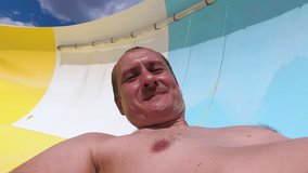 Slope Down by Water Slide in Water Park. Fun Travel Inside of the Multi Color Tube at Aqua Park Filmed on Action Camera. Father And Son Having Fun in Water Park on Week End