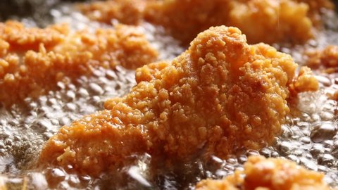 Crispy Chicken Drumsticks are Fried in Boiling Oil. Close up shot Adlı Stok Video