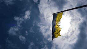 The wind is waving the flag of Ukraine against the background of the blue sky. Sun rays shine through fabric with high detail texture. Flag of Ukraine with national blue yellow color. Vertical video.