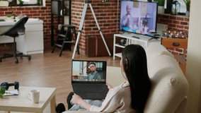 Office employee working remotely while attending online video call with executive manager on laptop at home. Asian woman discussing with coworker on internet conference while doing remote work.