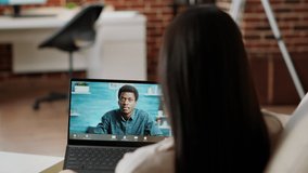Young adult woman talking to coworker on laptop virtual videocall meeting while working remotely. Person working from home while talking with manager on digital online videoconference call.