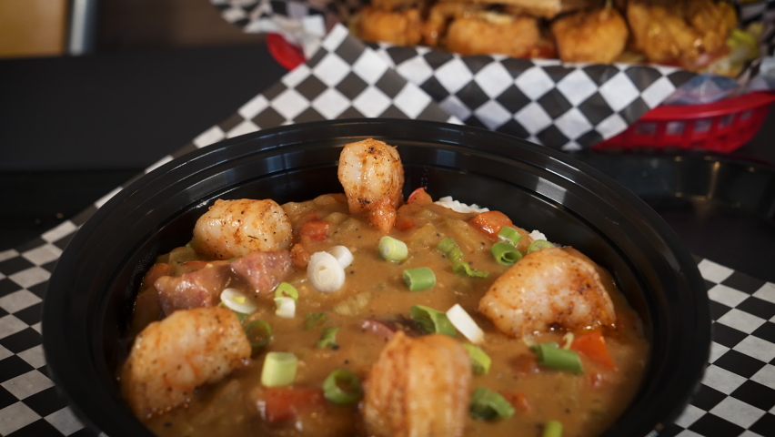 Bowl of traditional shimp sausage cajun etouffee topped with green onions, slider 4K