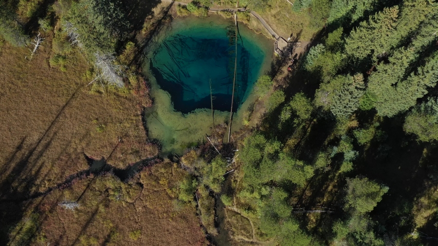 Aerial top down view flying past Little Crater lake with clear blue water located in the Mount Hood National Forest in the pacific northwest state of Oregon.