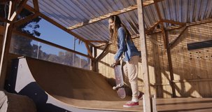 Video of happy caucasian female skateboarder training in skate park. Skateboarding, sport, active lifestyle and hobby concept.