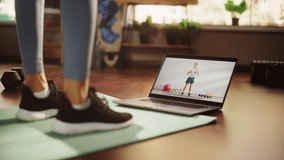 Woman Workout, Watching Trainer on Laptop, via Online Video Tutorial while Virtual Training at Home. Athletic Woman Using Streaming Service Fitness Subscription. Low Ground Shot of Legs and Laptop