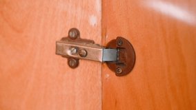 The work of the door hinge of an old wooden cabinet close-up. High quality 4k footage