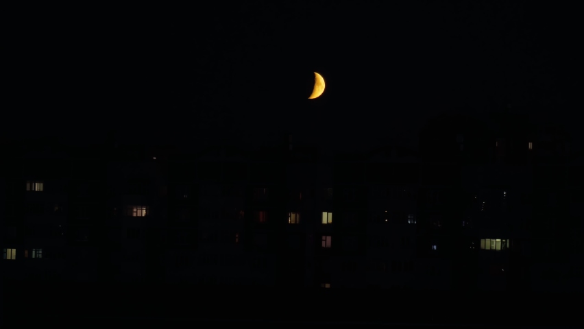 Crescent moon on the background of the night city, high rise buildings.