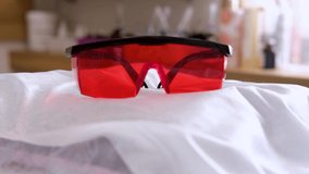 protective red glasses UV protection in cosmetology dentistry laser depilation teeth whitening. Slow motion video