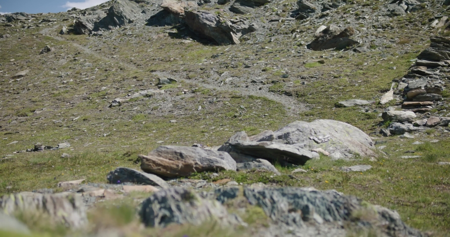 Black male traveler with backpack walking across screen to explore the Matterhorn mountainside in Switzerland
