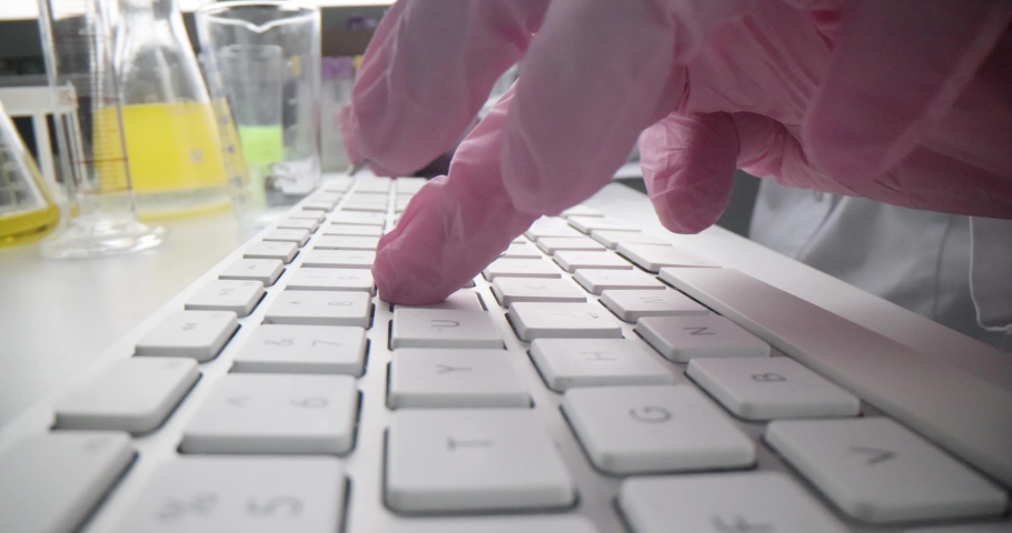 A chemist in a laboratory is typing on a computer keyboard Royalty-Free Stock Footage #1092397421