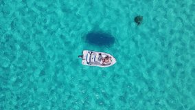 Aerial drone video of a boat anchored at the Blue Lagoon of Comino island, Malta, Europe