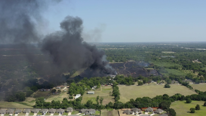 Rural field and forest burning, wildfire in sunny Texas, USA - Aerial approach