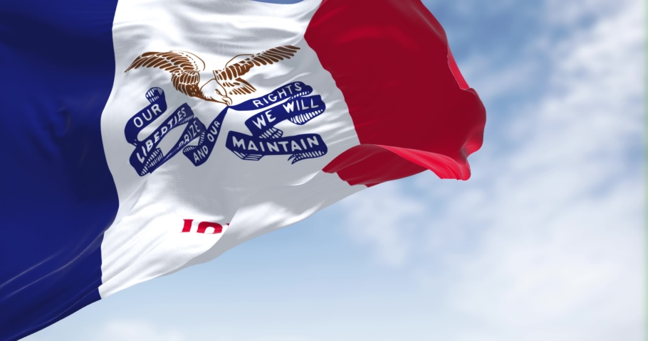 the flag of Iowa waving in the wind on a clear day. Iowa is a state located in the midwestern region of the United States. Seamless loop in slow motion