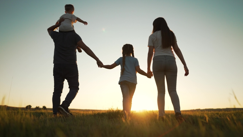 Happy family walk in field in nature.Parents and children are free and active people in nature.Healthy and cheerful family at picnic in the park.Summer walk in the park at sunset.Parents and children Royalty-Free Stock Footage #1092403573