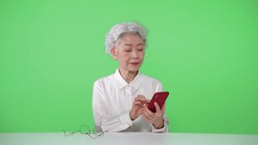 Elderly Asian woman. Green background for chroma key composition.