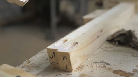 Slow motion. A professional carpenter takes a close-up of the details of furniture made of wood together.Assembling furniture in a carpentry workshop. Wood products for home decor.Lifestyle