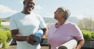 Vertical video of happy senior american african couple exercising. Retirement lifestyle, spending time alone,active leisure time.