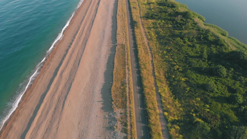 Aerial drone shot of cars driving along a scenic ocean highway Royalty-Free Stock Footage #1092424133