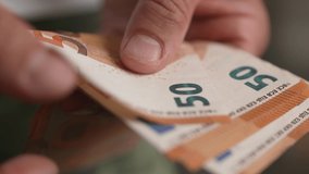 Close up male hands counting 50 euro money bills. Businessman paying with european banknotes. - Powered by Shutterstock - Get 15% off with code: PIKWIZARD15