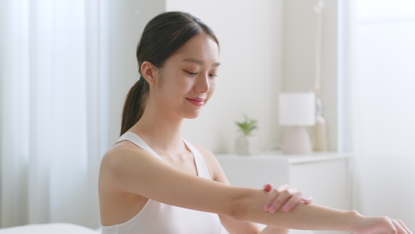 Young asian woman applying body lotion and skincare cream, beauty skin concept