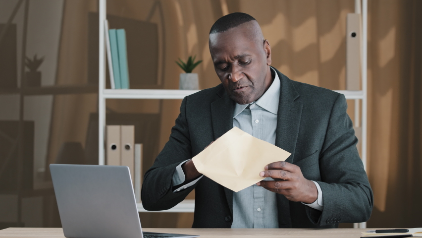African old man senior mature male in office opening paper envelope reading letter with good news. Happy elder retired businessman received investment notification banking loan approval salary bonus Royalty-Free Stock Footage #1092437037