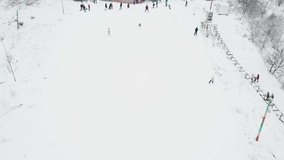 People skiing on a slope at ski resort. Aerial video