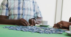 Video of happy senior african american couple doing puzzles. Retirement lifestyle, spending time together,active leisure time.
