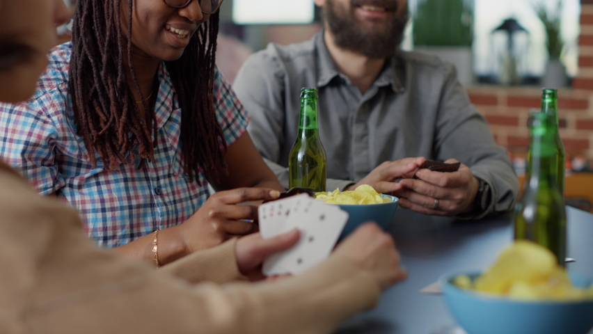 Competitive friends playing tactics cards game together, using strategy to have fun in living room. Happy men and women laughing and enjoying board games activity for entertainment. Royalty-Free Stock Footage #1092444483