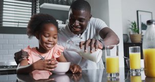 video of african american father and daughter eating breakfast. Enjoying quality family time together at home.