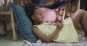 video of african american girl using tablet. Childhood and domestic life, using technology at home.