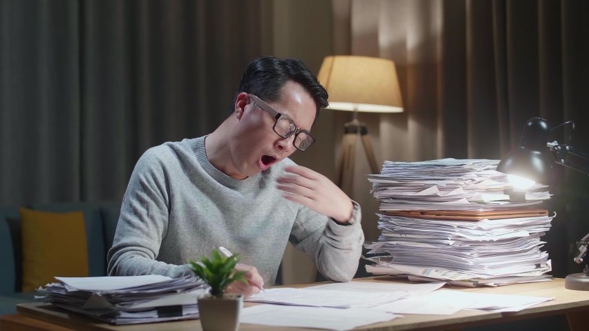 Tired Asian Man Yawning While Working Hard With Documents At Home
 | Shutterstock HD Video #1092448217