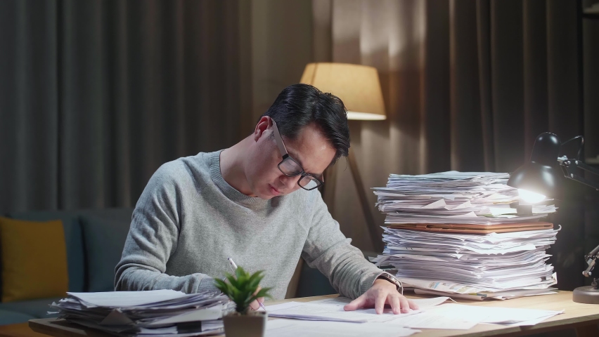 Tired Asian Man Shaking His Head While Working Hard With Documents At Home
 | Shutterstock HD Video #1092448219