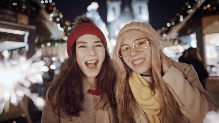 Christmas Beauty couple young multiracial woman asian girls wearing autumn dresses enjoying glamorous party having fun Europe night street. Friends dancing sparkling glowing sparklers fireworks light Royalty-Free Stock Footage #1092450905