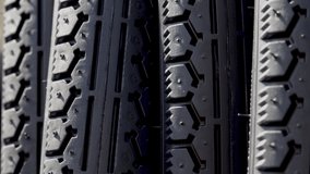 stack of black replacement bike tires for sale,outside sunny summer day.outdoor market.mountain bike tires with different rubber structure.high-volume, lightweight true racing bicycle tire 4k real - Powered by Shutterstock - Get 15% off with code: PIKWIZARD15