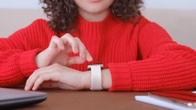 Girl using smartwatch gadget. Young white woman browsing notifications and messages on modern smart wrist watches
