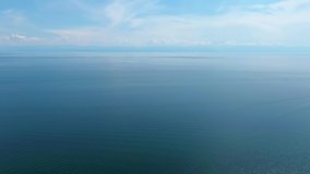 Aerial video footage in the open sea. There are no shores. Sky and blue waters. Top view. Drone footage.