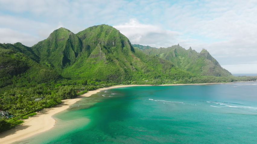 Cinematic Hawaii nature landscapes. Scenic NaPali coast with beautiful ridges jungle mountains. Incredible scenery of green lavish tropical peaks over turquoise ocean. Summer travel aerial background 