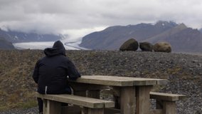Man looking at Mountain and Glacier in Iceland
