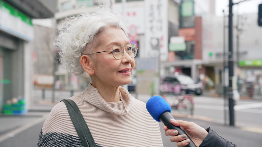 Elderly Asian woman undergoing a street interview. Royalty-Free Stock Footage #1092491763