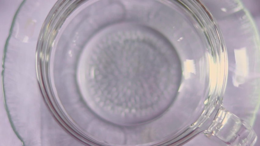 Vertical video top view of a timelapse of a dried butterfly pea flower diffusing blue color on a hot water