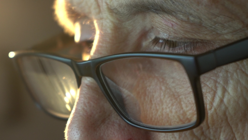 An elderly man with glasses looks at the computer screen. Royalty-Free Stock Footage #1092494597