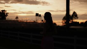 Silhouette video of healthy women is evening running and golden sunset background.