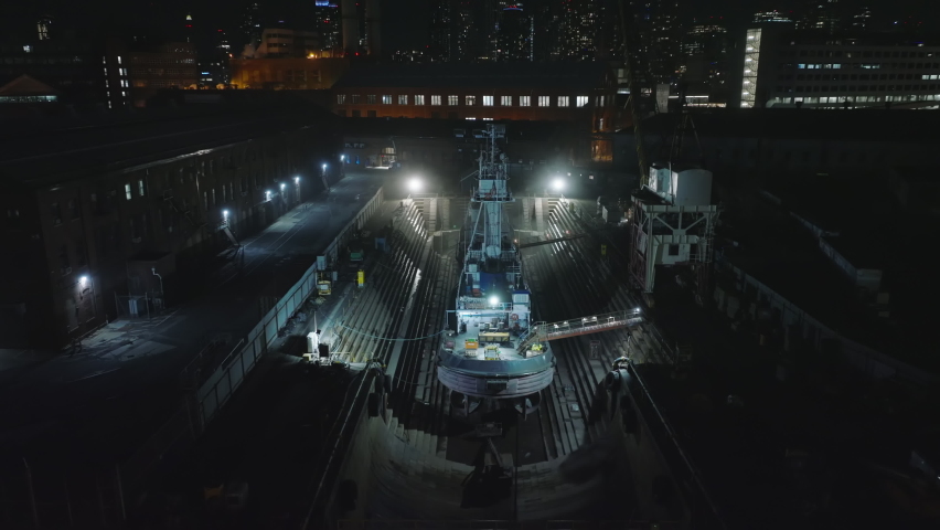 Aerial footage of ships in repair facility. Dockyard in city at night. Intensive lights illuminating vessels. Manhattan, New York City, USA Royalty-Free Stock Footage #1092498145