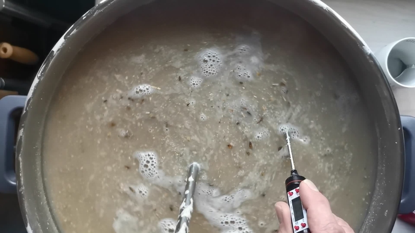 Top view slow motion of the mash of a home brewed pilsner being stirred and the correct temperature measured | Shutterstock HD Video #1092499577