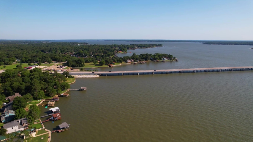 Aerial footage of Cedar Creek Lake in Texas. Drone approaches Cedar Creek Parkway.
