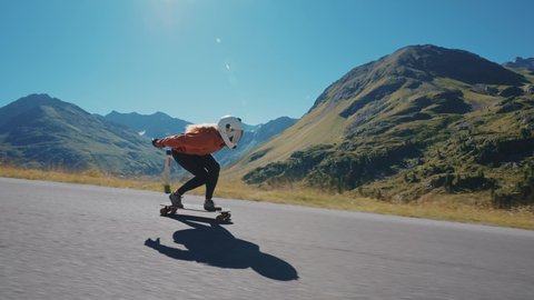 Cinematic downhill longboard session. Young woman skateboarding and making tricks between the curves on a mountain pass. Concept about extreme sports and peopleの動画素材