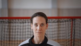 Close-up of woman floorball goalkeeper putting on helmet and preapring for game in gym. - Powered by Shutterstock - Get 15% off with code: PIKWIZARD15