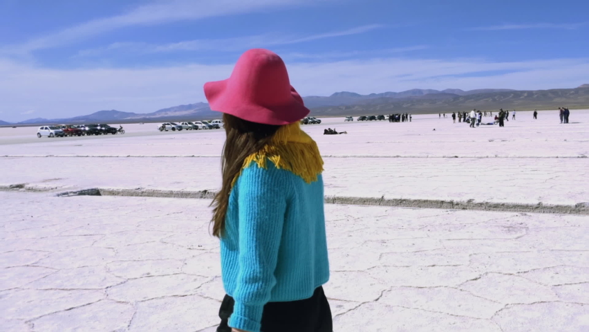 Woman in Pink Hat and Blue Sweater Walking at Salinas Grandes, Jujuy, Argentina